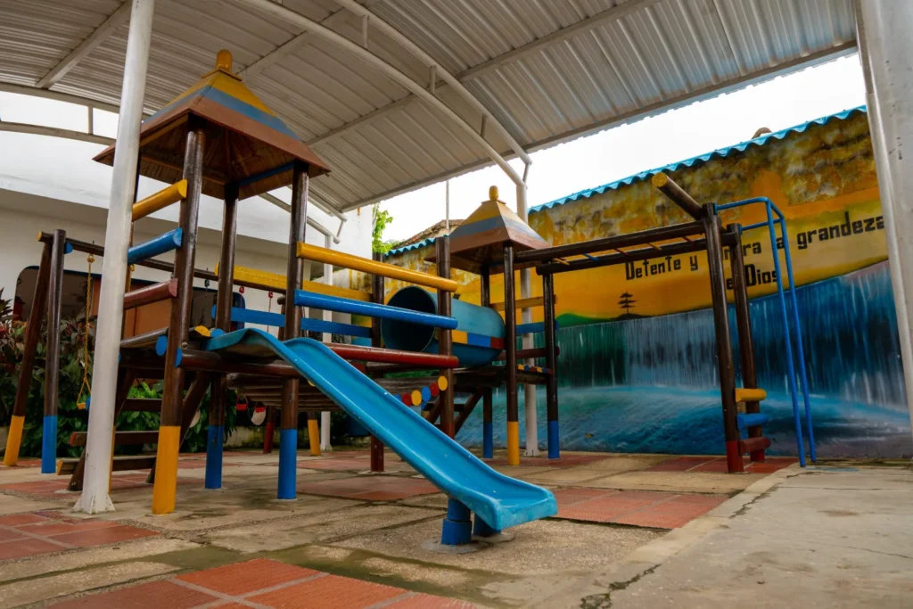 Zona de juegos infantiles con tobogán y estructuras de colores