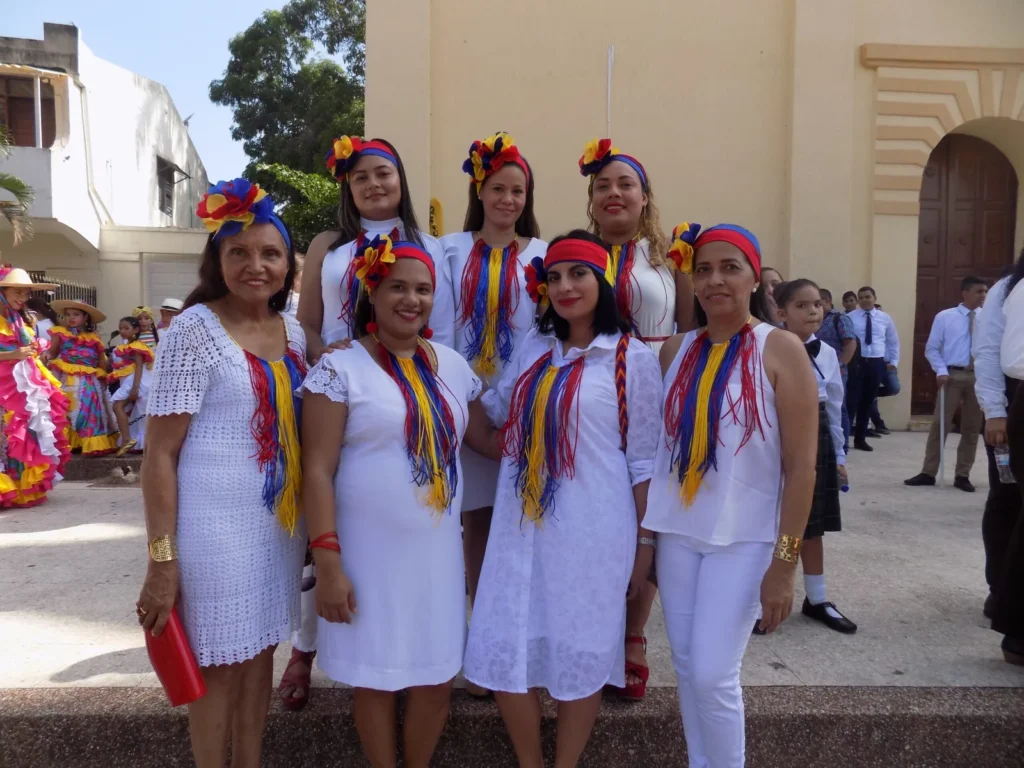 Grupo de bailarinas con trajes típicos blancos y de colores
