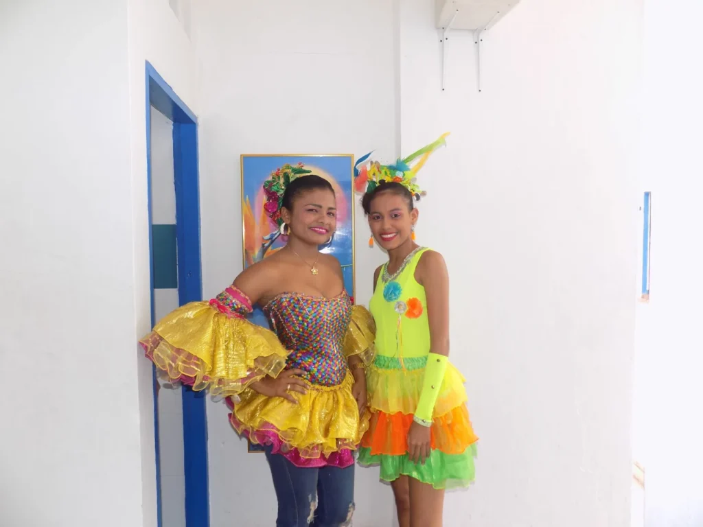 Dos niñas con trajes folclóricos coloridos en una presentación cultural