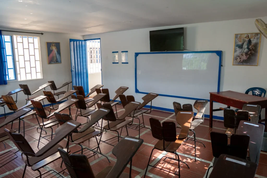 Salón de clases con pupitres y tablero